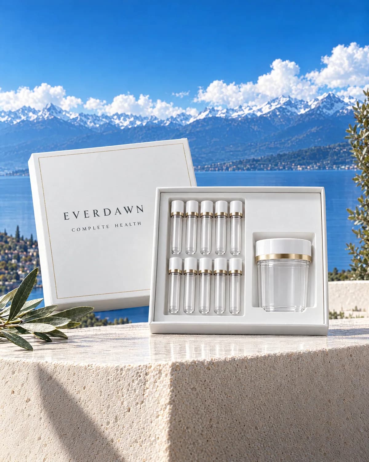 A white Everdawn box for the Complete Health Panel, open to show empty collection tubes and a specimen cup, on a terrace above a lake.