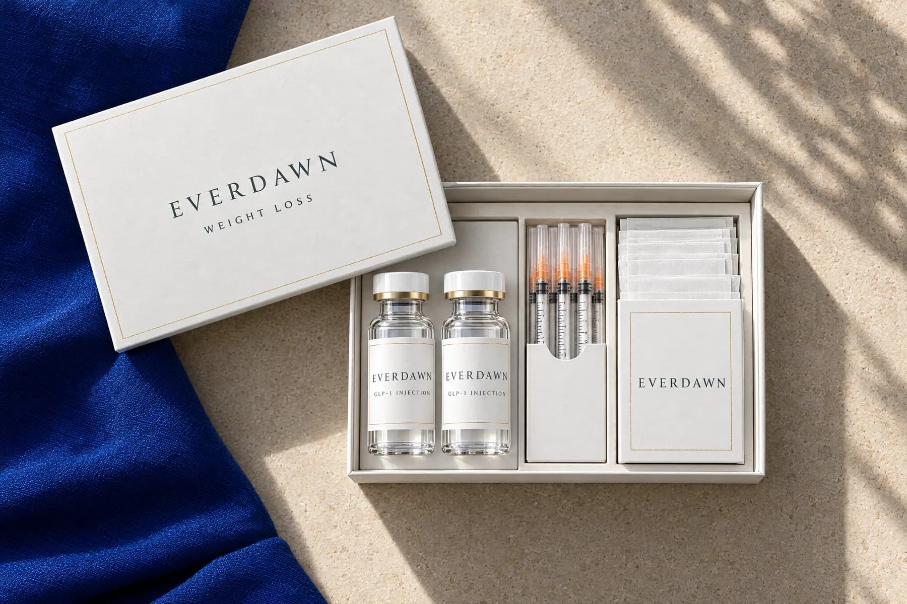 An opened Everdawn weight-loss kit with two vials, syringes, swabs and a care card