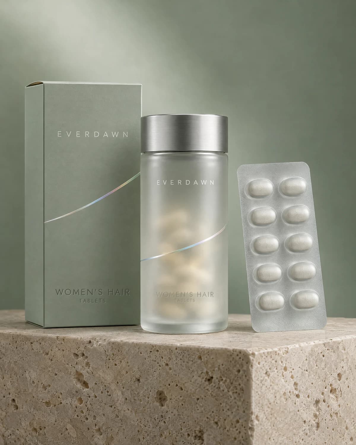 Illustrative packaging: a women’s hair tablet jar with its carton and a blister card on a travertine plinth against a soft studio background. Your medicine is labeled and dispensed by the licensed pharmacy.